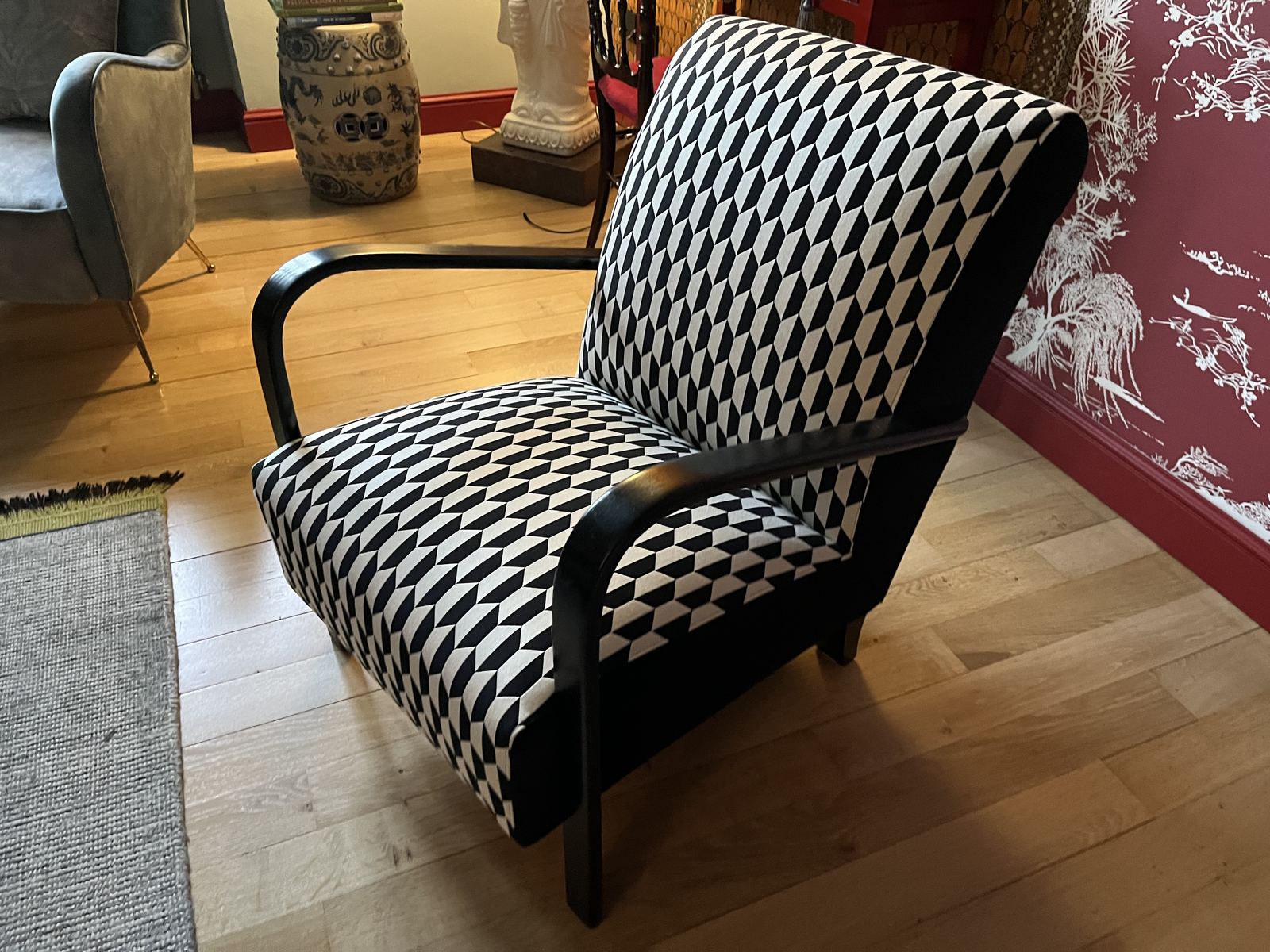 Wooden armchair upholstered in black and white cube-pattern fabric