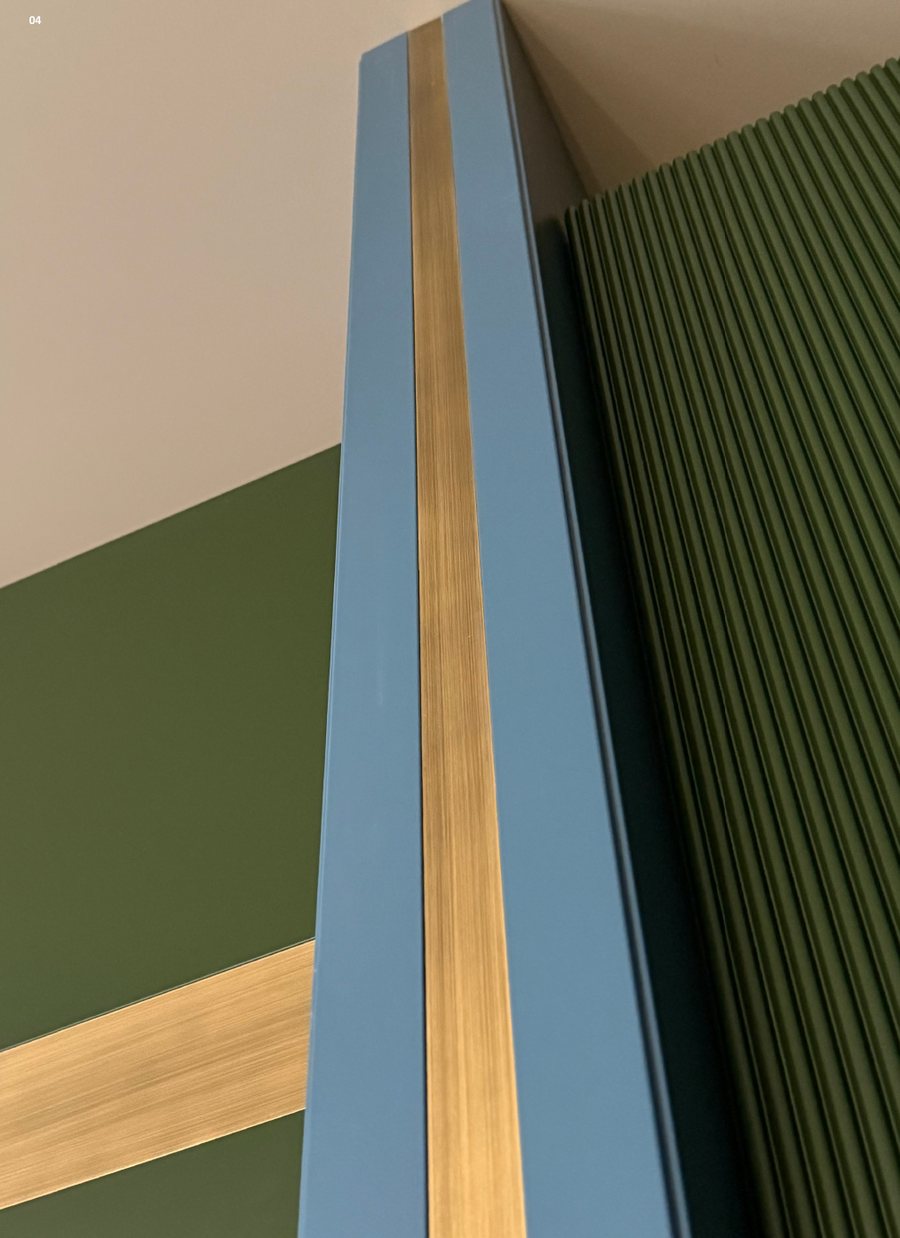 Blue joinery with a brass band against green fluted panels