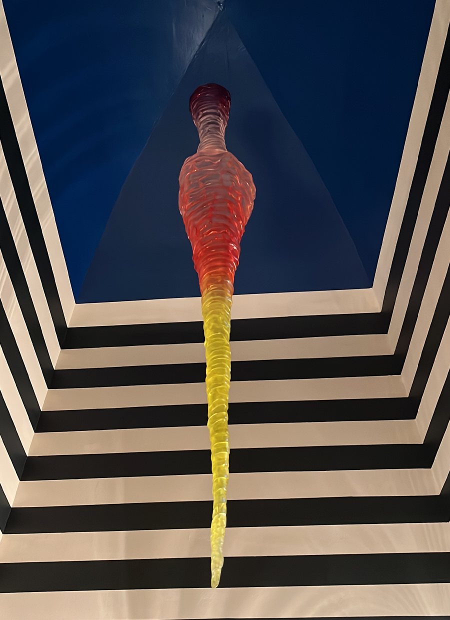 Glass sculpture hanging in a striped ceiling