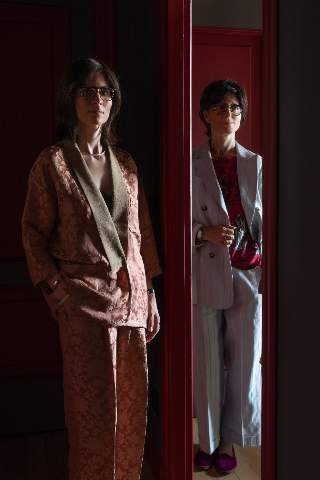 Naz Sida and Luana Blascetta, the founders of Atelier 8, standing either side of a red door frame